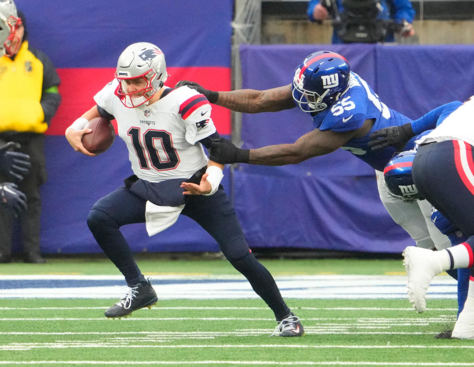 Nov 26, 2023; East Rutherford, New Jersey, USA; New York Giants linebacker Jihad Ward (55) has a hold on New England Patriots quarterback Mac Jones (10) in the 1st half at MetLife Stadium. Mandatory Credit: Robert Deutsch-USA TODAY Sports