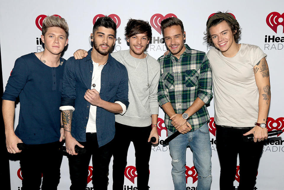 Niall Horan, Zayn Malik, Louis Tomlinson, Liam Payne, and Harry Styles at the iHeartRadio event, standing together and smiling at the camera