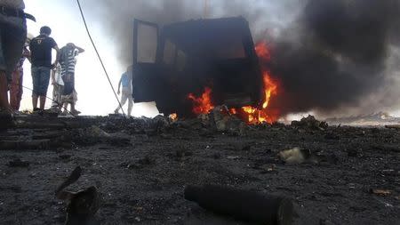 People watch a vehicle which belonged to Shi'ite Muslim rebels burn during clashes in Aden March 26, 2015. REUTERS/Nabeel Quaiti