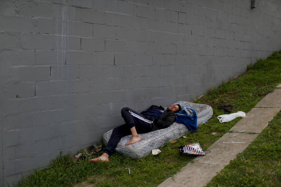 Un hombre duerme un colchón junto a una pared en un parque en Buenos Aires, Argentina, el lunes 30 de septiembre de 2019. (AP Foto / Natacha Pisarenko)