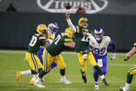 Green Bay Packers quarterback Aaron Rodgers (12) throws a pass while being chased by Los Angeles Rams' Aaron Donald (99) during the first half of an NFL divisional playoff football game Saturday, Jan. 16, 2021, in Green Bay, Wis. (AP Photo/Matt Ludtke)