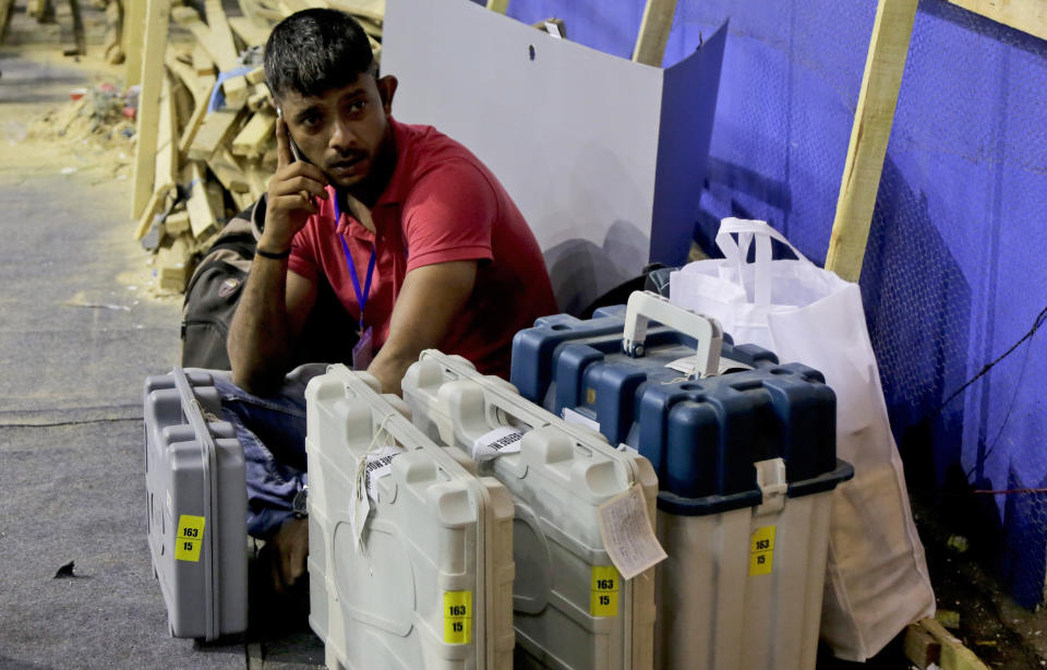 FILE- In this May 18, 2019 file photo, a polling officer sits with Electronic Voting Machines (EVM) at a distribution center on the eve of polls in Kolkata, India. India's Election Commission has rejected opposition fears of possible tampering of electronic voting machines ahead of Thursday's vote-counting to determine the outcome of the country's mammoth national elections. (AP Photo/Bikas Das, file)