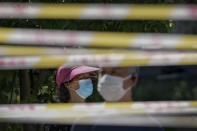 FILE - Residents wearing face masks line up behind barricaded tapes for COVID mass testing near a residential area on Sunday, May 15, 2022, in Beijing. (AP Photo/Andy Wong, File)