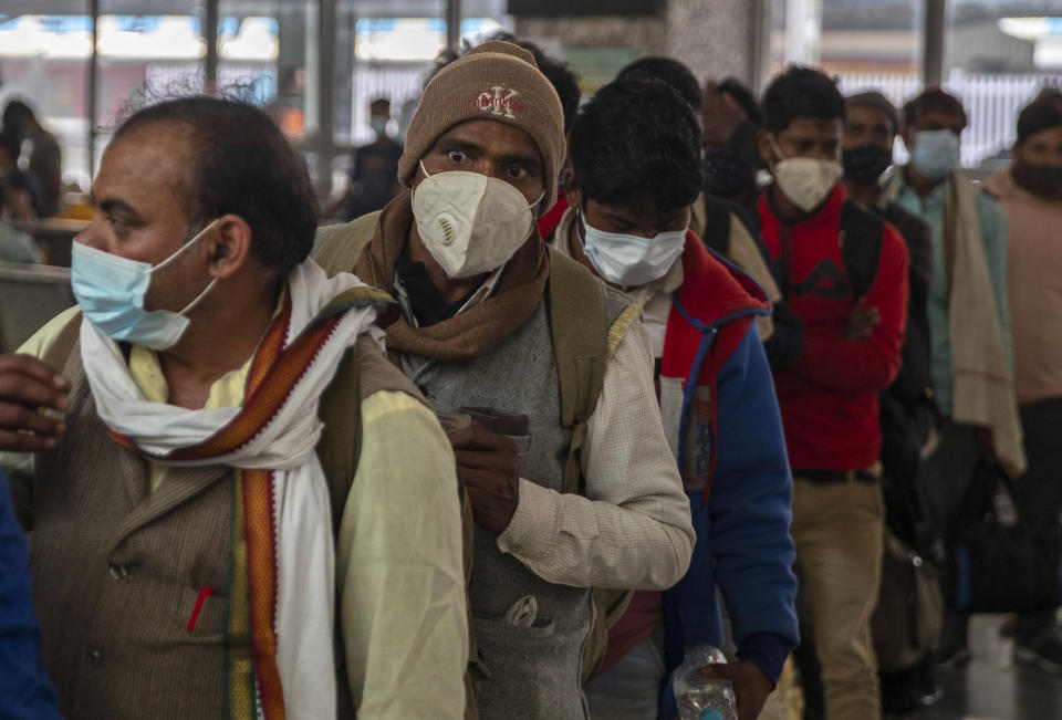 FILE - Passengers wearing face masks as a precaution against the coronavirus wait to get tested for COVID-19 at a railway station in Mumbai on Jan. 5, 2022. Coronavirus cases fueled by the highly transmissible omicron variant have rocketed through India and the country is scrambling to ward off its impact by swiftly introducing a string of restrictions that the population thought were history. But India’s political leaders, including Modi, have largely flouted some of these guidelines and traversed cities in a massive campaign trail ahead of crucial state polls, addressing packed rallies of tens of thousands of people without masks. (AP Photo/Rafiq Maqbool, File)