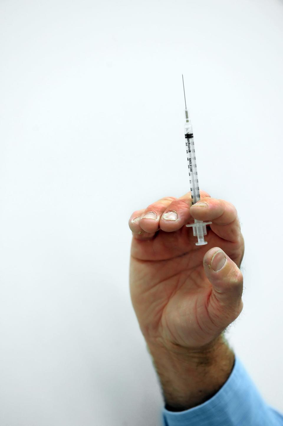 A pharmacist readies a flu shot.