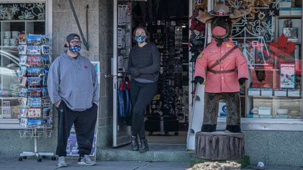 People standing outside a storefront in the ByWard Market on March 17.