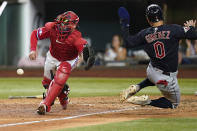 Cleveland Guardians' Andres Gimenez (0) scores on a single by teammate Will Brennan as Texas Rangers catcher Kevin Plawecki, left, reaches for the throw home from center field during the sixth inning of a baseball game in Arlington, Texas, Friday, Sept. 23, 2022. (AP Photo/LM Otero)