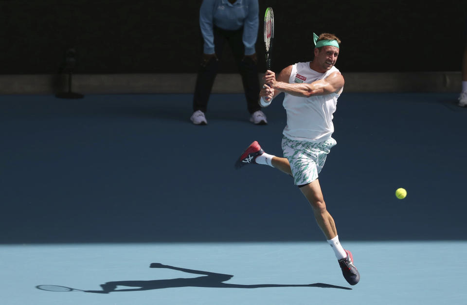 Tennys Sandgren of the U.S. makes a backhand return to Switzerland's Roger Federer during their quarterfinal match at the Australian Open tennis championship in Melbourne, Australia, Tuesday, Jan. 28, 2020. (AP Photo/Dita Alangkara)