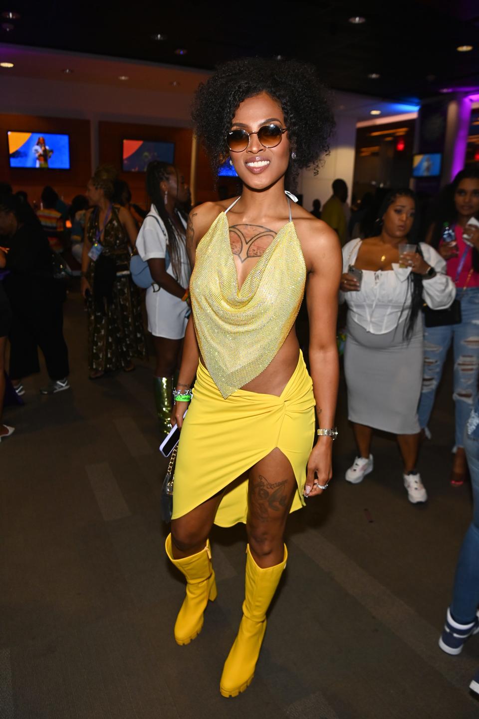 Marquita McSwain in a yellow sequin top, yellow skirt, and yellow boots
