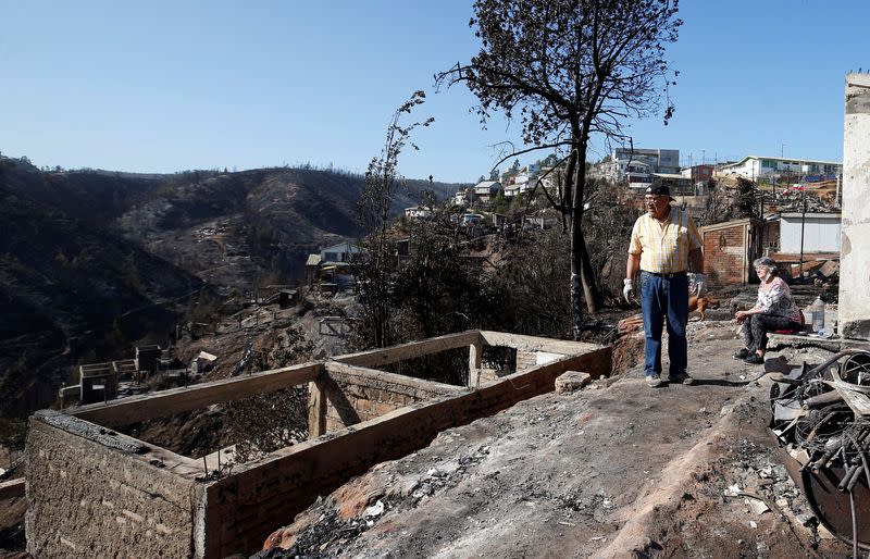 Pinto and husband Castro are seen next to the remains of their fire-destroyed house following spread of wildfires during an interview with Reuters in Valparaiso