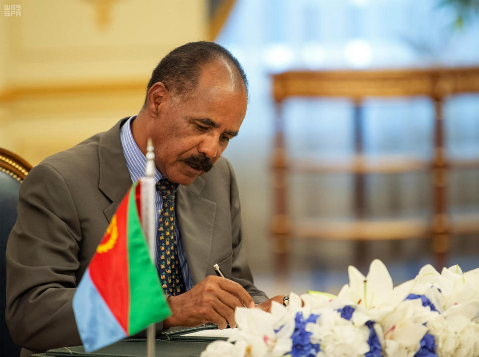 In this photograph released by the state-run Saudi Press Agency, Eritrean President Isaias Afwerki signs a peace accord with Ethiopia in Jiddah, Saudi Arabia on Sunday, Sept. 16, 2018. The leaders of Ethiopia and Eritrea were in Saudi Arabia on Sunday to sign a peace accord between the two East African nations. (Saudi Press Agency via AP)