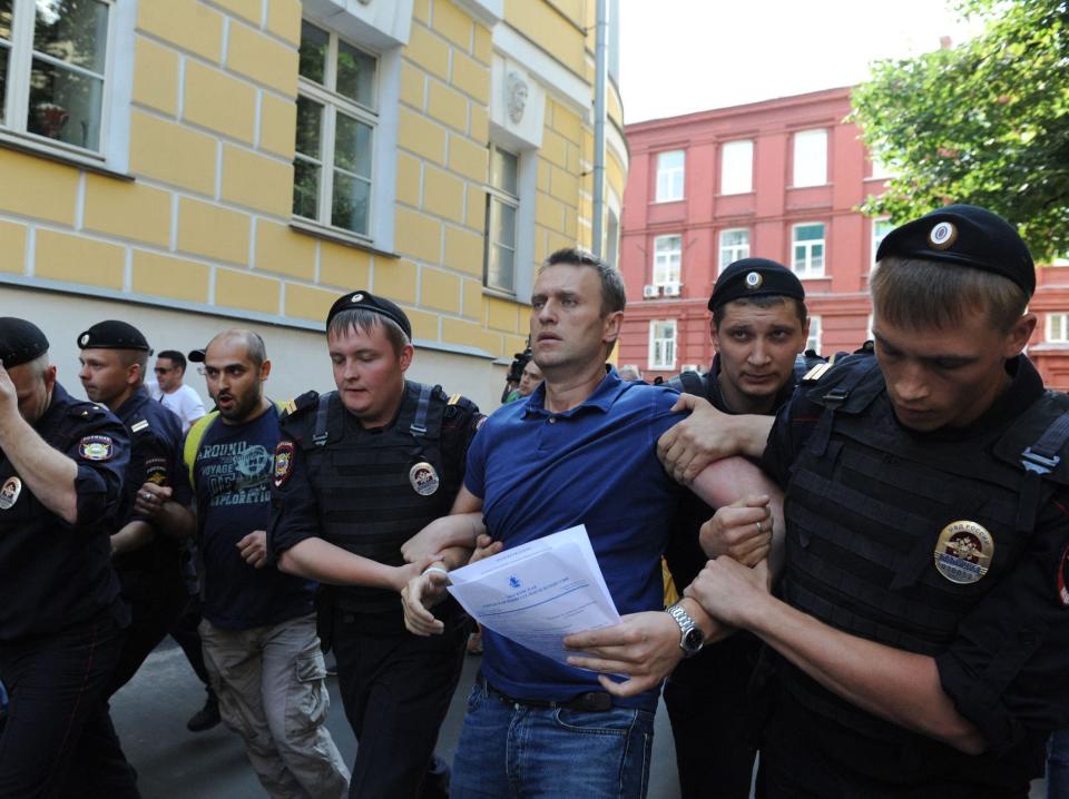 Police officers detain Alexei Navalny after his visit to the city's election commission office.