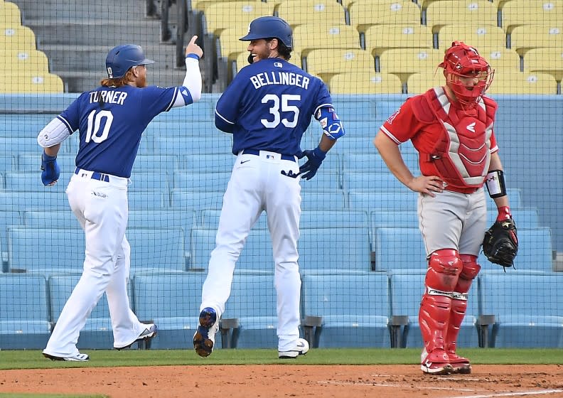 LOS ANGELES CALIFORNIA MARCH 30, 2021-Dodgers Cody Bellinger celebrates his two-run home run with Just Turner as Angels catcher Max Stassi looks on in the 1st inning during the Freeway Series at Dodger Stadium Tuesday. (Wally Skalij/Los Angeles Times)