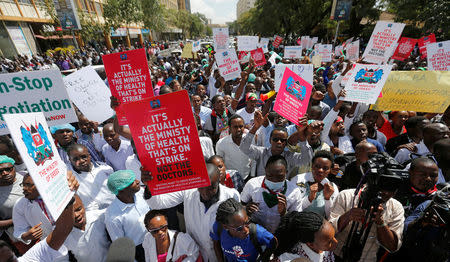 Striking doctors hold placards and chant slogans outside the Court of Appeal as they wait for the release of jailed officials of the national doctors' union in their case to demand fulfilment of a 2013 agreement between their union and the government that would raise their pay and improve working conditions in Nairobi, Kenya, February 15, 2017. REUTERS/Thomas Mukoya