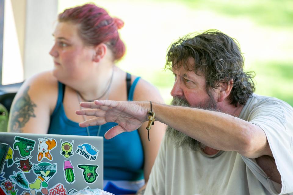 Pete, right, and Amy Cathlino talk about getting Pete a phone as the Grace Marketplace Street Team delivers drinks and sandwiches to homeless people in Northwest Gainesville on Aug. 14, 2023.
