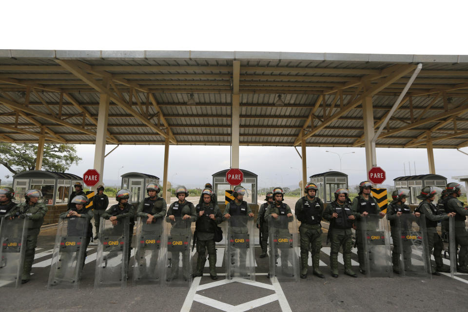 Venezuelan Bolivarian Guardsmen stand guard at the Tienditas International Bridge that links Colombia and Venezuela, near Urena, Venezuela, Friday, Feb. 8, 2019. As humanitarian aid kits were being packed into individual white bags in the city of Cucuta, just across the river from Venezuela, U.S. officials and Venezuelan opposition leaders appealed to the military to the let the aid through. (AP Photo/Fernando Llano)