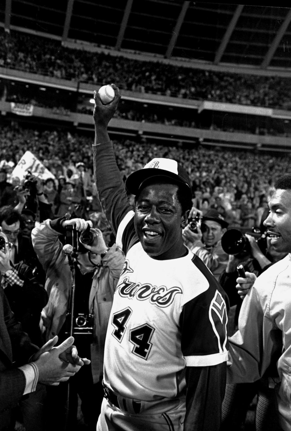 FILE - In this April 8, 1974 file photo, Atlanta Braves baseball player Hank Aaron holds the ball he hit for his 715th home run during a game against the Los Angeles Dodgers, in Atlanta. The 40th anniversary of Aaron's 715th home run finds the Hall of Famer, now 80, coping with his recovery from hip surgery. The anniversary of his famous homer on April 8, 1974 will be celebrated before the Braves' home opener against the Mets on Tuesday night. (AP Photo/Bob Daugherty, File)