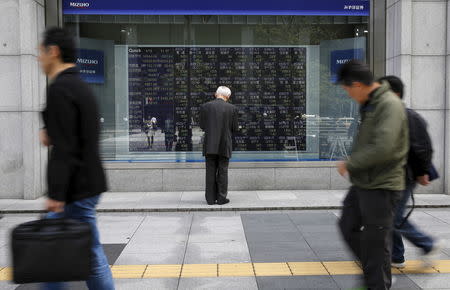 FILE PHOTO: A man looks at a stock quotation board outside a brokerage in Tokyo, Japan, April 18, 2016. REUTERS/Toru Hanai