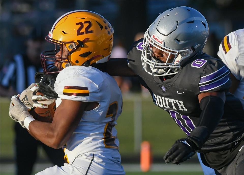 Bloomington South’s Ralph Rogers (0) tackles Bloomington North’s Kijuan Hayes (22) during the North-South football game at South on Friday, September 8, 2023.