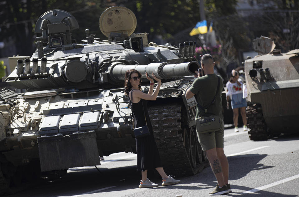 A Ukrainian woman poses for a photo with a tank, captured by Ukrainian forces during the war against Russia, on Khreshchatyk street, during Ukraine's 31st Independence Day celebrations in Kyiv, August 24, 2022. / Credit: Metin Aktas/Anadolu Agency/Getty