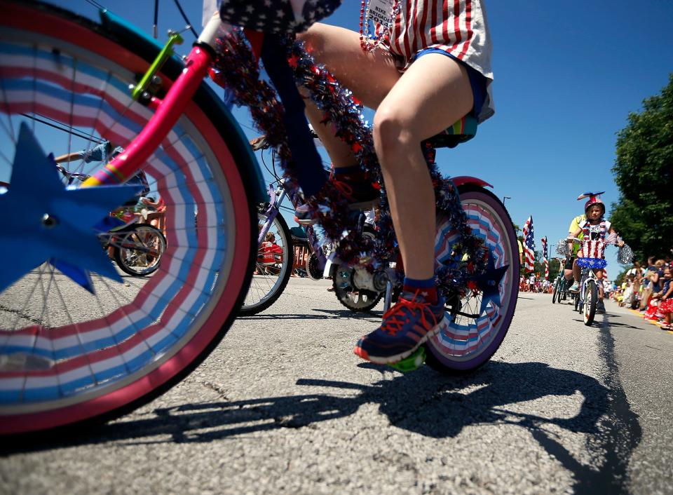 The bike brigade -- a group of children on bicycles adorned with patriotic colors and symbols -- rides In the City of Dublin Independence Day Parade.