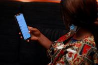 A woman looks at Nigerian banks apps on a smart phone in Abuja