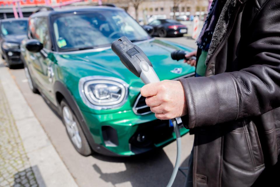 Ein Mann entfernt an einem Auto mit Plug-in-Hybrid-Antrieb in Berlin-Mitte das Ladekabel. Die internationale Automesse in China findet abwechselnd in Shanghai und Peking statt, in diesem Jahr vom 21. bis 28. April in Shanghai.