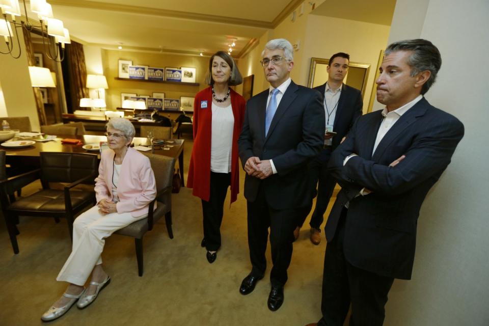 Jason Roe and Bill Bryant stand among a small group of people inside a residence.