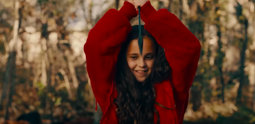 A little girl holds up a weapon