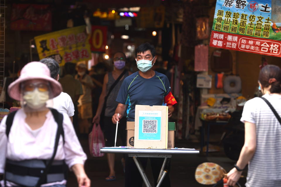 A member of staff stands at the entrance of a market making sure people are registered before shopping at the market amid the coronavirus disease (COVID-19) pandemic, in Taipei, Taiwan, July 6, 2021. REUTERS/Ann Wang