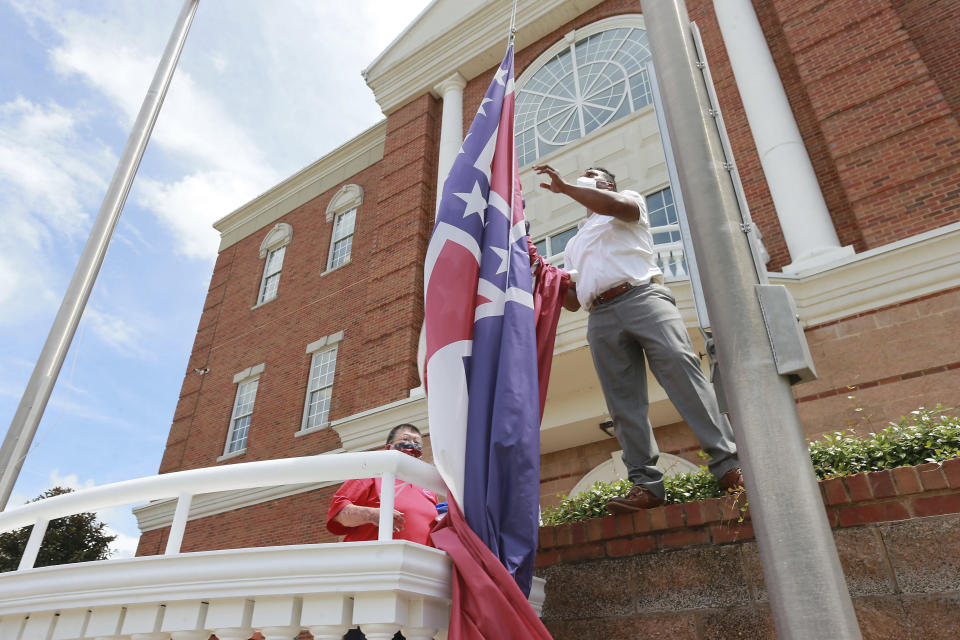 City of Tupelo Community Outreach Coordinator Marcus Gary takes down the State Flag of Mississippi that flew over the City Hall of Tupelo one last time Monday, June 29, 2020.Mississippi is retiring the last state flag in the U.S. that includes the Confederate battle emblem. (Thomas Wells/Northeast Mississippi Daily Journal, Via AP)