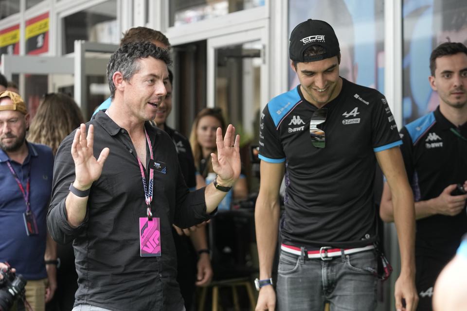 Rory McIlroy, left, of Northern Ireland, talks with Alpine driver Esteban Ocon, of France, before the sprint race ahead of the Formula One U.S. Grand Prix auto race at Circuit of the Americas, Saturday, Oct. 21, 2023, in Austin, Texas. (AP Photo/Darron Cummings)