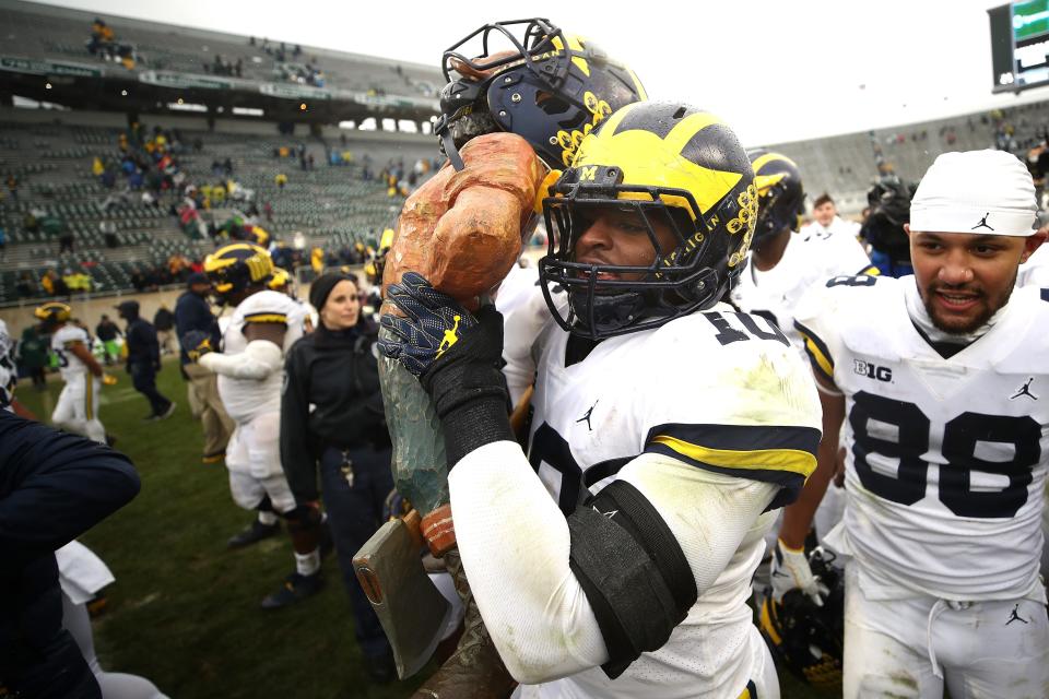 Michigan's Devin Bush carries the Paul Bunyan Trophy, after defeating Michigan State, 21-7, Saturday, Oct. 20, 2018, in East Lansing.