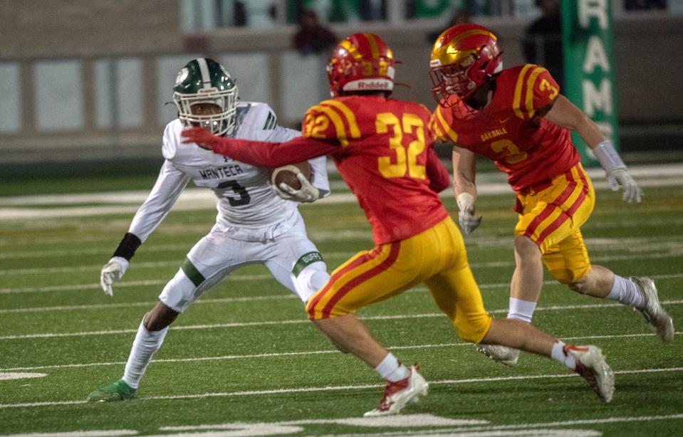 Manteca's Zion Allen, left tries to evade, Oakdale's Jake Kettering, center, and Rocky Richardson during the Sac-Joaquin Section Division III championship game at St. Mary's High School in Stockton. Manteca won 35-28.