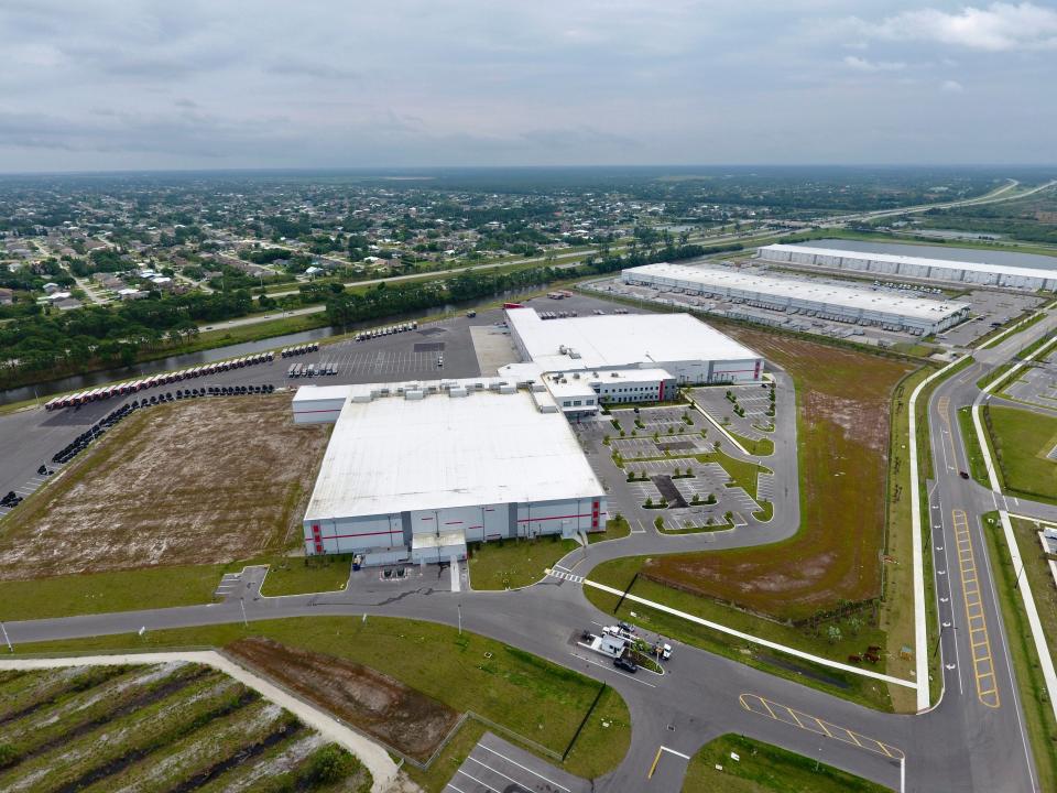 An aerial drone photograph shows the Cheney Brothers distribution warehouse in Port St. Lucie, located within the Southern Grove "jobs corridor" acquired by the city in 2018.