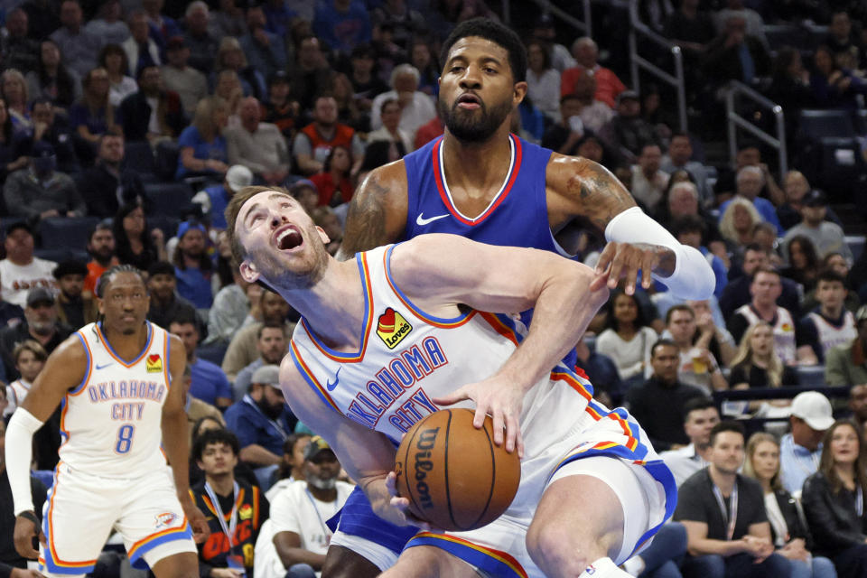 Oklahoma City Thunder forward Gordon Hayward, front, looks to shoot as Los Angeles Clippers forward Paul George defends during the first half of an NBA basketball game Thursday, Feb. 22, 2024, in Oklahoma City. (AP Photo/Nate Billings)