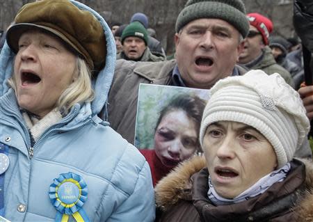 A protester holds a picture of journalist Tetyana Chornovil, who was beaten and left in a ditch just hours after publishing an article on the assets of top government officials, during a protest rally in front of the Ukrainian Ministry of Internal Affairs in Kiev December 25, 2013. REUTERS/Stringer