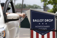 A voter drops off their mail-in ballot prior to the primary election, in Willow Grove, Pa., Wednesday, May 27, 2020. (AP Photo/Matt Rourke)