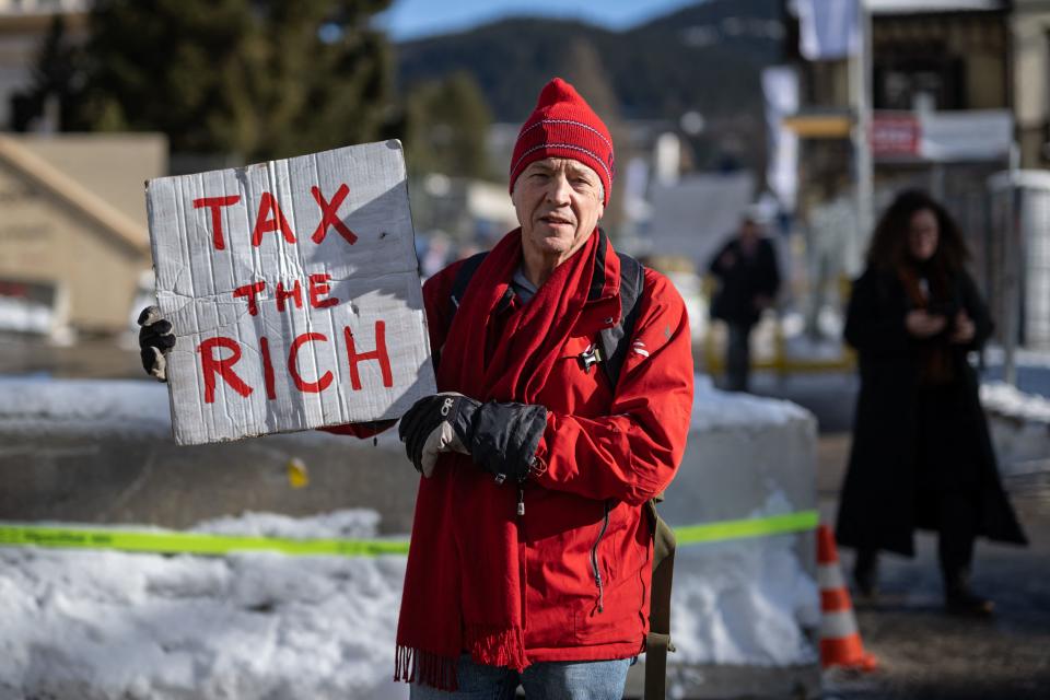 Phil White, a British millionaire poses with a placard reading: 