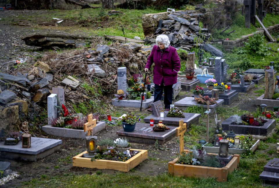 A woman walks on a partially destroyed cemetery in Altenahr in the Ahrtal valley, southern Germany, Monday, Dec. 13, 2021. The floods in July claimed almost 200 lives, many of them in the narrow Ahr Valley that's best known for its vineyards and as a picturesque hiking destination. (Photo/Michael Probst)