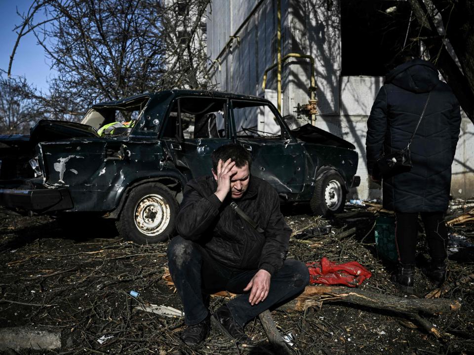 man sits outside his destroyed building after bombings on the eastern Ukraine town of Chuguiv (AFP via Getty Images)