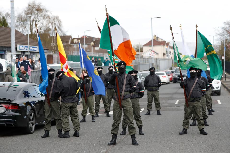 Masked Republican protesters opposed to the Good Friday Agreement hold Irish flags as they take part in a parade in Londonderry, Northern Ireland, Monday, April 10, 2023.