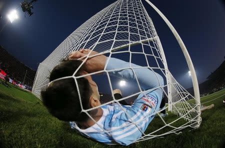 Argentina's Lionel Messi falls in the net during the Copa America 2015 final soccer match against Chile at the National Stadium in Santiago, Chile, July 4, 2015. REUTERS/Ivan Alvarado