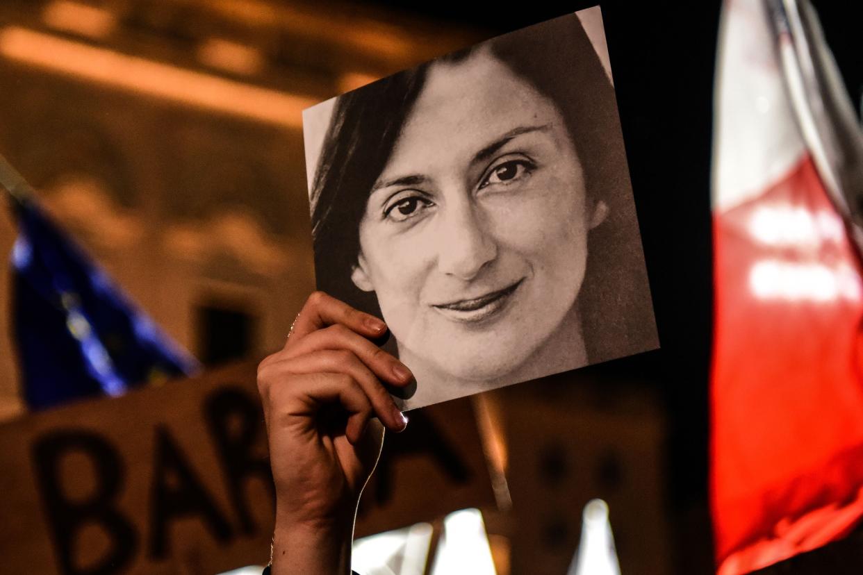 A person holds a photo of the killed journalist Daphne Caruana Galizia, during a protest in 2019 in Valletta (AFP via Getty Images)