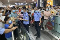 Police stand guard as supporters of Huawei CFO Meng Wanzhou gather at Shenzhen Bao'an International Airport in Shenzhen in southern China's Guangdong Province, Saturday, Sept. 25, 2021. China's government was eagerly anticipating the return of a top executive from global communications giant Huawei Technologies on Saturday following what amounted to a high-stakes prisoner swap with Canada and the U.S. (AP Photo/Ng Han Guan)