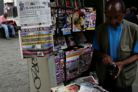 A man sells newspapers with the headline "There are no regional elections" in Caracas, Venezuela February 6, 2017. Picture taken February 6, 2017. REUTERS/Marco Bello