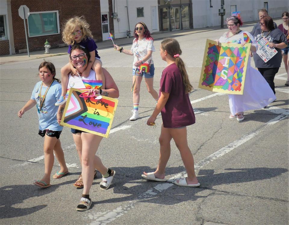 Chastin Burris marches with her children, Ezny and Havilynn, in Loogootee on June 12, 2022.