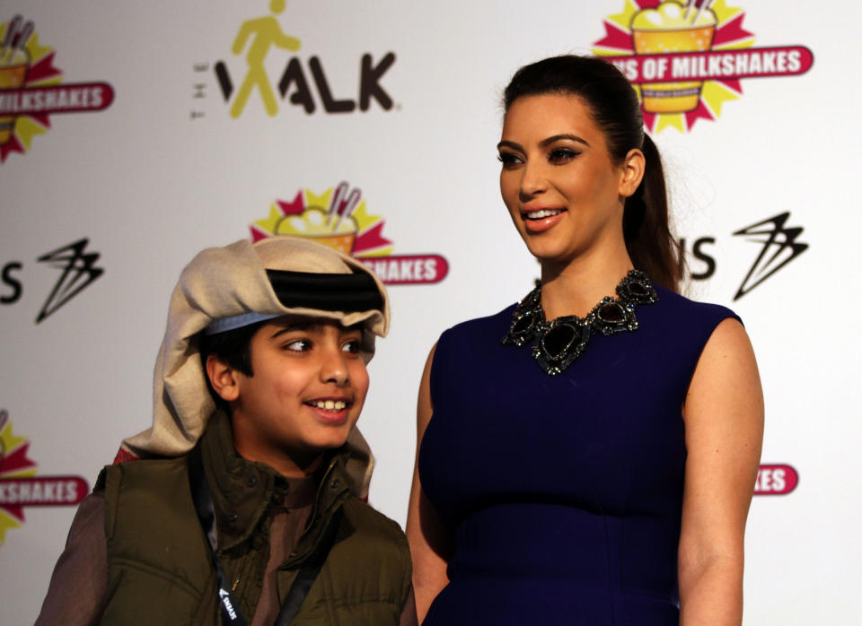 A young Bahraini smiles after having his picture taken with TV star Kim Kardashian, in Riffa, Bahrain, Dec. 1, 2012. Just hours after reality TV star Kim Kardashian gushed about her impressions of Bahrain, riot police fired tear gas to disperse more than 50 hardline Islamic protesters denouncing her presence in the Gulf kingdom. (AP Photo/Hasan Jamali)