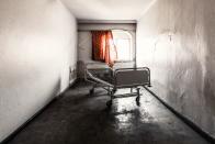 <p>A lone gurney left behind in a cold and empty hospital room.</p>