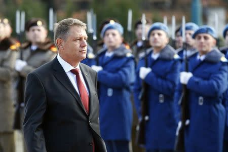 Romania's new President Klaus Iohannis walks in front of the honour guard during a take-over ceremony at Cotroceni presidential palace in Bucharest December 21, 2014. REUTERS/Bogdan Cristel